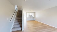Located at 6400 Preserve Crossing Blvd N in Gahanna, Ohio, this two-story, two-bedroom, two-bathroom home offers a well-designed layout spread across two floors. The main level features an open-concept living area with light hardwood flooring, neutral walls, and a large window that floods the space with natural light. The kitchen is thoughtfully appointed with white cabinetry, subway tile backsplash, light countertops, and stainless steel appliances including a refrigerator, electric range, and over-the-range microwave. A sliding glass door provides access to the outdoors and brings in additional natural light. Carpeted stairs lead to the upper level, where the primary bedroom offers two windows with outdoor views and plush carpeting. The second bedroom is equally comfortable with soft carpet and clean, neutral tones. Both bathrooms are finished in white, with one featuring a shower-tub combo and the other a glass-enclosed standing shower. A dedicated in-unit laundry area with a full-size washer and dryer adds everyday convenience. Two closets provide ample storage throughout the home. The overall aesthetic is clean, bright, and move-in ready.