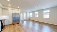 This 890-square-foot, single-floor apartment at 30950 Hanover Ln in Menifee, CA offers a clean, modern layout with 2 bedrooms, 1 bathroom, and 2 closets. The open-concept kitchen and living area serves as the heart of the unit, featuring light wood-style flooring, white shaker cabinetry extending to the ceiling, a white subway tile backsplash, gray countertops, and a full suite of stainless steel appliances including a gas range, built-in microwave, dishwasher, and a large side-by-side refrigerator. The spacious living area is filled with natural light from multiple windows with blinds and includes direct access to an outdoor balcony. Both bedrooms are carpeted and bright, each featuring windows with neighborhood views. The primary bedroom measures 150 square feet and includes access to a generous walk-in closet equipped with multi-tier wire shelving. The full bathroom is finished with wood-style flooring, a white vanity with gray countertop, and a tiled tub-shower combination with built-in shelving niches. A hallway connects all rooms efficiently, maintaining a practical and comfortable flow throughout the home.