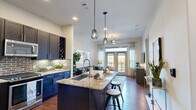 Located in Southside Place, Texas, this thoughtfully designed one-bedroom, one-bathroom residence offers a well-appointed open-concept layout that maximizes both function and style. The combined kitchen and living area serves as the heart of the home, anchored by a large central island with granite countertops and bar seating — ideal for casual dining and entertaining. The kitchen features bold dark cabinetry, stainless steel appliances, a gas range, an exposed brick tile backsplash, and a built-in wine rack, lending the space a refined yet approachable character. Rich hardwood flooring runs throughout the main living area, complemented by recessed lighting and striking geometric pendant lights above the island. The living room is bright and inviting, with floor-to-ceiling French doors that open onto a private balcony, offering outdoor views and abundant natural light. A ceiling fan adds comfort to both the living area and bedroom. The carpeted bedroom is a calm retreat, featuring a walk-in closet and large windows that fill the room with natural light. The bathroom is finished with granite countertops, dark cabinetry, and a full tub-shower combination with tasteful tile surround. Throughout, the design strikes a balance between modern elegance and everyday livability.