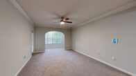 Located at 500 Briarvista Way in Atlanta, GA, this single-floor, 3-bedroom, 4-bathroom home offers a well-designed layout with thoughtful architectural details throughout. Elegant arched doorways and crown molding lend a refined character to the interior, while neutral tones and plush carpeting create a warm, cohesive ambiance across the living spaces.

The entry foyer transitions seamlessly into the main living areas via a graceful arched hallway with hardwood-style flooring. The open-concept kitchen, dining, and living area serves as the heart of the home, featuring a granite-topped breakfast bar, white cabinetry, stainless steel appliances, and a gas range. The living room is generously sized, accented by a ceiling fan and a large arched window that invites natural light and outdoor views.

The spacious primary bedroom includes a ceiling fan and ample room, complemented by an ensuite bathroom. Two additional carpeted bedrooms provide comfortable accommodations, each with access to closets — six closets in total ensure exceptional storage throughout. One bathroom features a classic pedestal sink with an oval mirror, adding a clean, timeless touch.

A dedicated laundry room with side-by-side washer and dryer adds everyday convenience, completing this well-appointed home.
