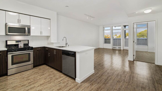 Cocina y sala de estar con balcón y pisos de superficie resistente - Parc on Powell