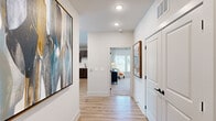 Located at 300 Highway 81 in McDonough, GA, this well-appointed three-bedroom, two-bathroom single-story home offers a thoughtfully designed layout with modern finishes throughout. Light wood-look flooring flows through the main living areas and hallways, while recessed lighting and clean white walls create a bright, welcoming atmosphere.

The inviting hallway serves as the central artery of the home, connecting each room with ease and featuring large-scale artwork that adds a contemporary touch. The kitchen is a standout, boasting rich dark cabinetry, stainless steel appliances, a subway tile backsplash, and a granite-topped island with seating for multiple guests, illuminated by striking pendant lights. The spacious living room is bathed in natural light from multiple large windows with plantation shutters and features a ceiling fan and durable wood-look flooring.

The generously sized primary bedroom offers a serene retreat with large windows, plush carpet, and access to a well-appointed closet with built-in wire shelving. The bathrooms are finished with clean, modern fixtures, including a glass-enclosed walk-in shower with matte black hardware and marble-style tile surround. The two additional bedrooms are comfortable and bright, each with ample natural light and carpet flooring. Two closets provide excellent storage throughout the home.