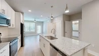 Located at 350 Bay Laurel Dr in Saint Augustine, FL, this thoughtfully designed one-bedroom, one-bathroom residence offers a clean, modern aesthetic throughout its efficiently utilized single-floor layout. The open-concept kitchen serves as the heart of the home, showcasing a granite-topped island with an undermount sink, sleek white shaker cabinetry, stainless steel appliances including a refrigerator, range, and microwave, and stylish pendant lighting. Light wood-look flooring flows through the main living and kitchen areas, creating a seamless, airy feel. The living area benefits from natural light through multiple windows with blinds and is finished with a ceiling fan for added comfort. The generously sized primary bedroom features plush carpeting, large windows, and a ceiling fan, offering a comfortable retreat. The bathroom is well-appointed with a granite vanity, white cabinetry, wood-look flooring, and a tiled shower-tub combination. A dedicated walk-in closet with wire shelving provides ample storage, while a separate in-unit laundry room with a full-size washer and dryer adds everyday convenience. The overall ambiance is bright, clean, and contemporary.