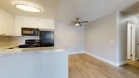 Located in Redlands, CA, this single-floor, 3-bedroom, 2-bathroom residence offers a well-designed layout with a clean, neutral aesthetic throughout. The open-concept kitchen serves as a central hub, featuring white shaker-style cabinetry, granite-look countertops, a peninsula with an integrated sink, and black appliances including a refrigerator, electric range, and microwave. The kitchen flows seamlessly into the living area, which is finished with warm wood-look luxury vinyl flooring and a ceiling fan with light fixture — a detail echoed in the bedrooms as well.

The living spaces are bright and airy, with soft neutral wall tones and textured ceilings that add subtle dimension. The primary bedroom is generously sized and benefits from a window with blinds that allows natural light to filter in. The additional bedrooms share a similar finish with the same wood-look flooring and windowed walls offering views of surrounding greenery.

Both bathrooms are finished with granite-look countertops, white cabinetry, and wood-look tile flooring. One bathroom features a walk-in shower with tile surround. A dedicated closet provides added storage. The space also includes a private outdoor patio accessible via sliding glass doors, offering an open-air retreat with views of the surrounding neighborhood.