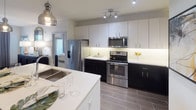 Located at 6348 W Longboat Blvd in Tampa, Florida, this contemporary single-floor residence offers a thoughtfully designed layout with modern finishes at every turn. The kitchen serves as a central showpiece, boasting a striking two-tone cabinetry scheme with crisp white upper cabinets and dark lower cabinets, complemented by white quartz countertops, a large center island with a double sink, pendant lighting, and a full suite of stainless steel appliances. Wood-look tile flooring ties the space together seamlessly. The primary bedroom is a serene retreat featuring plush carpeting, a ceiling fan, and access to a generous walk-in closet. Its en-suite bathroom impresses with a marble-tiled glass-enclosed shower, a dual-sink vanity with dark cabinetry and white quartz counters, and dark wood-look tile flooring. Additional bedrooms offer comfortable carpeted spaces with ample natural light through large windows and ceiling fans. A secondary bathroom mirrors the refined aesthetic with a single-sink vanity and direct bedroom access. Throughout the residence, a cohesive neutral color palette, recessed and track lighting, and carefully curated design details create a polished, modern ambiance ideal for contemporary living in the Tampa Bay area.