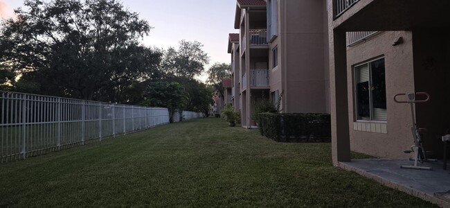 Back area of unit, across from a park with a lake, child playground, dog area, pool, and mini-beach - 10650 SW 157th Ct