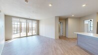 Located in Fairway, Kansas, this well-appointed 3-bedroom, 5-bathroom residence offers a clean, modern aesthetic across a single, efficiently organized floor. The open-concept living, dining, and kitchen area serves as the heart of the home, featuring light hardwood-style flooring, neutral walls, and floor-to-ceiling sliding glass doors that lead to a private balcony with outdoor views. The kitchen is outfitted with light wood cabinetry, white quartz countertops, stainless steel appliances, open shelving, and a classic subway tile backsplash. Each bedroom is carpeted and includes ceiling fans, with select rooms offering balcony-facing windows that bring in generous natural light. The primary bedroom features its own dedicated closet space with built-in shelving and hanging rods for ample storage. The four additional closets throughout the residence provide further organizational convenience. The five bathrooms are finished with large-format marble-look tile, glass-enclosed showers with built-in benches, warm wood vanities, and white countertops, delivering a refined, spa-like atmosphere. A dedicated laundry room and utility room add practical functionality. The overall ambiance is bright, modern, and move-in ready.