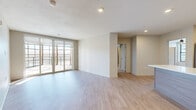 Located in Fairway, Kansas, this well-appointed 3-bedroom, 5-bathroom residence offers a clean, modern aesthetic across a single, efficiently organized floor. The open-concept living, dining, and kitchen area serves as the heart of the home, featuring light hardwood-style flooring, neutral walls, and floor-to-ceiling sliding glass doors that lead to a private balcony with outdoor views. The kitchen is outfitted with light wood cabinetry, white quartz countertops, stainless steel appliances, open shelving, and a classic subway tile backsplash. Each bedroom is carpeted and includes ceiling fans, with select rooms offering balcony-facing windows that bring in generous natural light. The primary bedroom features its own dedicated closet space with built-in shelving and hanging rods for ample storage. The four additional closets throughout the residence provide further organizational convenience. The five bathrooms are finished with large-format marble-look tile, glass-enclosed showers with built-in benches, warm wood vanities, and white countertops, delivering a refined, spa-like atmosphere. A dedicated laundry room and utility room add practical functionality. The overall ambiance is bright, modern, and move-in ready.