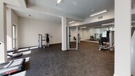 Located at 417 Centinela Ave in Inglewood, California, this fitness center offers a well-equipped, single-floor workout facility designed with both functionality and comfort in mind. The space features a clean, modern aesthetic with crisp white walls, structural columns, and durable dark rubber flooring suited for high-impact exercise.

Natural light fills the cardio area through large windows that frame views of the surrounding neighborhood, creating an open and energizing atmosphere. Two treadmills are positioned near the windows to take advantage of the natural light and outdoor views, making cardio sessions more engaging.

The strength training area is generously sized, providing ample room to move freely between a variety of cable and resistance machines. A full rack of dumbbells is neatly organized along a mirrored wall, which spans a significant portion of the gym and enhances the sense of space while allowing users to monitor their form during workouts.

Overhead, recessed and linear LED lighting ensures consistent illumination throughout the entire facility. The open floor plan allows for flexible use of the space, accommodating both machine-based and free-weight training with ease. The overall ambiance is bright, clean, and professional, offering an inviting environment for a comprehensive fitness routine.