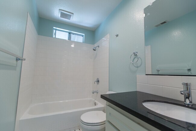 Totally updated bathroom with full-sized tub, granite countertops, LED lights and all new tile. - 122 West Main Avenue Apartments
