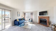 Located at 2100 Eastwood Dr in Fort Collins, Colorado, this single-floor residence offers a well-organized layout with multiple distinct living spaces. The living room serves as a welcoming centerpiece, featuring plush carpeting, a classic brick fireplace, and a large window that allows natural light to fill the room. Sliding glass doors lead to a private balcony, extending the living space outdoors and offering views of surrounding greenery.

The kitchen is thoughtfully designed with white shaker cabinetry, light countertops, and a full suite of stainless steel appliances, including a refrigerator, dishwasher, microwave, and range. A breakfast bar with seating provides a casual dining option and opens toward the main living area, creating an open, connected feel.

The bedrooms vary in configuration, with one featuring a closet with built-in organization and direct access to a private en-suite bathroom. A secondary bedroom offers generous natural light through a wide window. An additional flexible room with built-in shelving functions well as a home office or study area. Luxury vinyl plank flooring and carpet are used throughout, complementing the unit's clean, neutral palette.