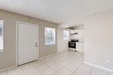 Located at 115 SW 16th St in Pompano Beach, Florida, this single-story, 2-bedroom, 1-bathroom home offers a practical and efficient layout. The interior is finished with light-toned ceramic tile flooring throughout, creating a cohesive and easy-to-maintain living environment well-suited to the South Florida climate.

The combined living, dining, and kitchen area forms the heart of the home. The living room is bright, featuring multiple windows that allow natural light to fill the space, and opens directly to the kitchen. The kitchen is equipped with white cabinetry, a stainless steel electric range, a range hood, and light stone countertops, offering a clean and functional cooking space.

Both bedrooms feature neutral, warm-toned walls, tile flooring, and natural light from windows with blinds. The spacious primary bedroom includes a built-in closet with a rod and shelf system. In total, the home offers three closets, providing ample storage throughout. A hallway connects the bedrooms to the shared bathroom, which includes a full bathtub and shower combination with tiled surround walls.

The textured ceilings are consistent throughout the home, contributing to its classic Florida residential character. This well-organized home presents a straightforward, functional living space in an established Pompano Beach neighborhood.
