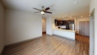 This well-designed single-floor residence offers a clean, contemporary aesthetic throughout. The open-concept living and kitchen area serves as the heart of the home, featuring durable wood-look flooring and a ceiling fan overhead. The kitchen is a standout, outfitted with dark espresso cabinetry, stainless steel appliances including a range, microwave, and refrigerator, a white quartz countertop peninsula with an undermount sink, stylish pendant lighting, and a subway tile backsplash — ideal for both everyday cooking and entertaining.

The bedrooms are comfortable and bright, each carpeted and equipped with ceiling fans and windows fitted with blinds that allow for natural light and outdoor views. One bedroom features direct access to a walk-in closet, adding practical storage.

The bathrooms reflect the same modern sensibility found throughout the space. The primary bathroom includes dark wood cabinetry, a white countertop vanity, a large mirror, an overhead cabinet for storage, and access to a walk-in closet. A secondary bathroom offers a full tub-shower combination with classic subway tile surround, tile flooring, and clean white walls. Together, these spaces present a cohesive, functional, and modern living environment.