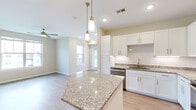 Located at 824 Lemon Dr in Lake Saint Louis, MO, this well-appointed 2-bedroom, 2-bathroom residence offers a thoughtfully designed single-level layout that maximizes both comfort and functionality. The open-concept kitchen and living area serves as the heart of the home, anchored by a granite-topped center island illuminated by stylish brass pendant lights. The kitchen is outfitted with crisp white shaker-style cabinetry, a classic subway tile backsplash, gleaming granite countertops, and a full suite of stainless steel appliances, including a range, microwave, dishwasher, and refrigerator. Light hardwood-style flooring flows seamlessly through the main living areas, lending the space a clean, contemporary feel. The living room benefits from natural light through multiple windows and is complemented by a ceiling fan. Both bedrooms feature plush carpeting and closet storage, with the primary bedroom offering a comfortable, well-proportioned retreat. The bathrooms echo the home's refined aesthetic with granite vanity tops, white cabinetry, and a tub-shower combination. Recessed lighting throughout enhances the bright, airy ambiance of this move-in-ready home in Lake Saint Louis.
