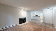 Located at 420 85th Pl SW in Everett, WA, this two-bedroom, one-bathroom unit offers a practical and comfortable single-floor layout. The living room serves as the heart of the home, featuring a fireplace with a tile hearth, neutral carpet, a textured ceiling, and baseboard heating. Track lighting illuminates the space, which opens toward a dedicated dining area and a sliding glass door that leads to a private balcony overlooking surrounding trees. The kitchen is efficiently laid out with wood-look flooring, white cabinetry with updated hardware, light countertops, and black appliances including a refrigerator, electric range, and dishwasher. A pass-through counter connects the kitchen to the dining area, enhancing the open feel. The primary bedroom offers a comfortable footprint with a sliding closet, a window providing natural light and exterior views, and plush carpet throughout. The second bedroom mirrors a similar layout with its own sliding closet and a window overlooking the exterior. The bathroom includes a full soaking tub and shower combination with a clean, white surround. A hallway connects the main living areas to the bedrooms and bathroom, keeping the layout straightforward and functional throughout.