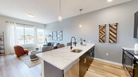 Located at 169 North Main Street in Port Chester, NY, this thoughtfully designed one-bedroom, one-bathroom residence offers a smart, functional layout across a single floor. Light-toned hardwood flooring flows throughout, tying together each room with a cohesive, contemporary aesthetic.

The open-concept kitchen is a standout, featuring dark cabinetry with gold hardware, a striking quartz waterfall island with seating for several, a matte black faucet, and stainless steel appliances — all illuminated by elegant pendant lighting. The kitchen transitions seamlessly into the living room, which benefits from large windows offering views of the surrounding Port Chester neighborhood, filling the space with natural light.

The generously sized bedroom also enjoys large windows with outdoor views and ample room to furnish comfortably. Three closets, including a spacious walk-in, provide excellent storage throughout the unit. A dedicated office adds versatility to the floorplan, ideal for remote work or a private study.

The bathroom is clean and modern, with neutral tile flooring, a soaking tub with subway tile surround, and matte black fixtures. A hallway with a sliding barn door adds an architectural accent, while an in-unit laundry area adds everyday convenience.