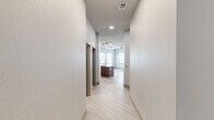 Located at 3000 Seventh Ave S in Birmingham, Alabama, this single-floor unit showcases a clean, contemporary design with a thoughtfully planned open layout. Light-toned luxury vinyl plank flooring runs throughout the main living areas, complementing the neutral color palette and creating a cohesive, modern aesthetic.

The kitchen serves as a focal point of the space, featuring flat-front wood-grain cabinetry extending to the ceiling, stainless steel appliances, a mosaic tile backsplash, and a large center island with a quartz countertop and undermount sink. Track lighting overhead highlights the workspace, while the open configuration allows seamless flow into the living area, which benefits from multiple windows that invite generous natural light.

A hallway connects the main living zone to the private quarters. The bedroom features soft carpeting, a ceiling fan, and a sliding barn door that opens to a bathroom with a tub/shower combination clad in large-format tile, built-in shelving, a wood-tone vanity, and recessed lighting. A second bathroom offers a glass-enclosed shower, dual-sink vanity with a wood-framed mirror, and tile flooring. Additional conveniences include an in-unit stacked washer and dryer tucked behind a sliding barn door.