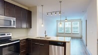 Located at 5290 Big Island Dr in Jacksonville, FL, this well-designed one-bedroom residence offers a thoughtful single-floor layout that maximizes comfort and functionality. The open-concept kitchen and living area form the heart of the home, where rich dark-espresso cabinetry contrasts beautifully with granite countertops and a full suite of stainless steel appliances, including a dishwasher, range, and refrigerator. A peninsula with pendant lighting provides additional counter space and anchors the kitchen's modern aesthetic, while a glass tile backsplash adds a refined touch. Track lighting and tile flooring complete the kitchen zone. The living area flows seamlessly from the kitchen, featuring warm wood-look flooring, a ceiling fan, and a large bank of windows that flood the room with natural light and offer outdoor views. The generously sized primary bedroom is carpeted for comfort and features dual windows with blinds, providing both brightness and privacy. A dedicated closet and adjacent bathroom access add practicality. A utility closet near the entrance provides additional storage. Clean white walls and neutral tones throughout create a bright, cohesive ambiance that is both modern and inviting.