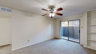 Located at 22221 Cypresswood Dr in Spring, TX, this single-floor, one-bedroom, one-bathroom unit offers a well-organized layout designed for comfortable everyday living. The combined kitchen and living area serves as the heart of the home. The galley-style kitchen is outfitted with white cabinetry, dark granite-look countertops, white appliances including a range, microwave, and dishwasher, and durable wood-look flooring. A peninsula counter connects the kitchen to the living area, which features plush carpeting, a ceiling fan with light, and a built-in shelving unit for added storage. Sliding glass doors lead to a private outdoor patio, allowing natural light to fill the space. The bedroom is generously sized with soft carpet, a ceiling fan, and a window that brings in additional natural light. A dedicated closet provides ample storage. The bathroom features white cabinetry with dark countertops, a single-basin sink, a full tub-shower combination with tile surround, and wood-look flooring that ties into the rest of the unit. A separate laundry area and hallway complete the efficient, functional floor plan, making this unit a practical and comfortable living option.