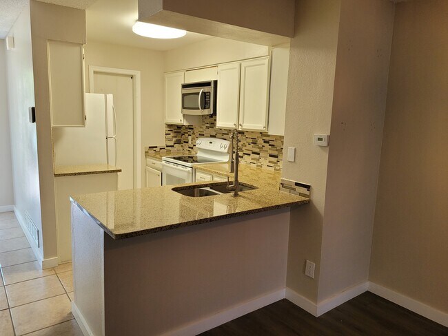 Kitchen with 1/2 bath behind barn door - 1228 S Idalia St