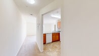 Located at 245 Main St in Toms River, NJ, this one-bedroom, one-bathroom residence offers a well-organized single-floor layout designed for efficient, comfortable living. The open-concept living and dining area is bright and inviting, featuring soft carpeted flooring, a ceiling light fixture, and a large double-hung window that fills the space with natural light and street views. The kitchen is positioned adjacent to the living area, separated by a half-wall peninsula with granite-style countertops. Warm honey-toned wood cabinetry, a tile floor, and white appliances — including a dishwasher, electric range, and built-in microwave — complete the functional cooking space, which also benefits from a skylight overhead. A hallway connects the main living area to the private quarters, including the bedroom, bathroom, closet, and laundry area. The bedroom is generously proportioned with plush carpeting, a large street-facing window, and a sliding-door closet with interior rod and shelving. The bathroom features a full tub-shower combination, a wood-cabinet vanity with a white countertop, a mirrored medicine cabinet, and clean tile flooring. In-unit laundry adds everyday convenience to this neatly appointed Toms River residence.