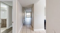 Located at 349 Scottsdale Square in Winter Park, Florida, this 2-bedroom, 1-bathroom residence offers a well-organized single-floor layout with a clean, modern aesthetic throughout. The interior features light wood-look luxury vinyl flooring across the main living areas and bedrooms, complemented by neutral warm-gray walls and crisp white trim and baseboards.

The living room is generously proportioned, offering an open, airy feel with natural light streaming in through sliding glass doors that lead to a private balcony. The updated kitchen stands out with bright white shaker-style cabinetry, stone-look quartz countertops, a decorative mosaic tile backsplash, and a window above the sink that adds natural light to the space.

The primary bedroom is spacious and includes floor-to-ceiling mirrored closet doors, crown molding, and multiple windows that allow ample daylight. The second bedroom features its own closet with classic paneled doors and a window with a view to the outside. Both bedrooms share warm neutral tones and wood-look flooring.

The full bathroom is well-appointed with a tiled tub-shower combination and clean white fixtures. Two hallways efficiently connect the rooms, and the textured ceilings are consistent throughout. The layout is functional and cohesive, making this a practical and comfortable Winter Park residence.