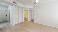 Located at 101 Cimarron Trl in Irving, TX, this two-story, 2-bedroom, 1-bathroom home offers a well-organized layout across two levels. The main living area features light wood-look flooring throughout, a bright open-concept design, and a tiled fireplace that serves as a focal point in the living room. The kitchen is outfitted with stainless steel appliances including an electric range and over-the-range microwave, bold navy-blue cabinetry, white countertops, and a subway tile backsplash. A convenient in-unit laundry area with a full-size washer and dryer is tucked nearby. The bathroom features light wood-look flooring, a full tub-shower combo, and a navy vanity that ties in with the kitchen's color scheme. Both bedrooms are carpeted and feature ceiling fans; the primary bedroom includes built-in shelving and direct access to the bathroom, while the second bedroom offers two windows that bring in natural light. A dedicated closet provides additional storage. The attached garage is equipped with an automatic opener and offers ample space. Crown molding and textured ceilings add character throughout, creating a cohesive and functional living environment.