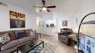 Located at 550 N Harrison Rd in Tucson, AZ, this single-story residence offers a well-designed two-bedroom, two-bathroom layout that maximizes functionality and comfort. Light wood-style flooring runs throughout the home, creating a cohesive and airy feel.

The open-concept living area serves as the heart of the home, featuring a ceiling fan overhead and a seamless flow into the dining area and kitchen. The kitchen is equipped with white cabinetry, light stone countertops, and black appliances including a range, microwave, and refrigerator. A pass-through design connects it naturally to the living and dining spaces.

The dining area comfortably accommodates a full table and is framed by clean white walls. Both bedrooms feature ceiling fans, large windows that invite natural light, and easy access to the bathrooms. The primary bedroom includes a closet with mirrored sliding doors, adding depth to the room.

The two bathrooms offer distinct configurations: one includes a vanity with a medicine cabinet mirror and a tub-shower combo, while the second features a walk-in shower with built-in shelving and a grab bar. Both are finished with white tile and light countertops. A hallway connects the private areas of the home efficiently, completing this practical and comfortable Tucson residence.