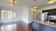 Located at 163 Franklin St in downtown Stamford, CT, this modern single-floor residence offers a well-designed layout with contemporary finishes throughout. The open-concept living and dining area is anchored by rich, dark hardwood flooring that extends across the main living spaces, complemented by crisp white walls and large windows that invite generous natural light. Track lighting adds a sleek, functional touch overhead.

The kitchen is a standout feature, showcasing dark espresso cabinetry, a granite-topped island with an integrated sink, and a full suite of stainless steel appliances including a refrigerator, gas range, and built-in microwave. Pendant lighting above the island adds warmth and style to this well-appointed cooking space.

The bedroom areas offer a contrast in flooring — one room features the same gleaming hardwood as the living area, while another is finished with neutral carpeting, providing a softer, more comfortable feel. Both rooms are bright, with windows offering views to the surrounding neighborhood.

The bathroom is finished with large-format tile flooring, white subway tile surrounding a full soaking tub and shower, and a dark-cabinetry vanity that ties into the home's consistent design aesthetic. Clean lines and neutral tones define the overall ambiance, creating a modern and cohesive living environment throughout.