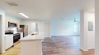 This 790 square foot apartment, located at MacAlpine Place, offers a well-designed single-floor living space. The unit comprises one bedroom, measuring 180 square feet, one bathroom, a combined kitchen and living room area, and a convenient in-unit laundry.

The interior is characterized by its modern aesthetic and efficient use of space. Hardwood floors run throughout the apartment, providing a warm and cohesive look. Large windows in the bedroom and living area flood the space with natural light and offer pleasant outdoor views, enhancing the sense of openness.

The bathroom features a clean, contemporary design with a white vanity, toilet, and shower/tub combination. The kitchen is equipped with stainless steel appliances, including a refrigerator, stove, and built-in microwave. Light-colored cabinetry and countertops contribute to the bright, airy feel of the space.

The living area is spacious enough to accommodate comfortable seating and includes a ceiling fan for added comfort. The bedroom, while compact, offers ample space for a bed and essential furniture, with a closet for storage.

This apartment combines functionality with modern design elements, creating an inviting living space ideal for singles or couples seeking a contemporary urban lifestyle.