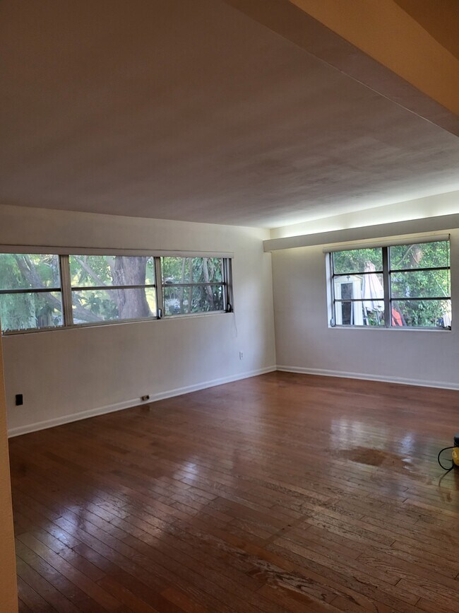 Large living room with hardwood floors and lots of windows for natural light - 4425 Bradley Ave
