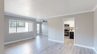 Located at 724 Lewelling Blvd in San Leandro, CA, this single-floor, 2-bedroom, 1-bathroom residence offers a thoughtfully designed layout with modern finishes throughout. The living room is a bright, open space featuring light wood-style flooring, crown molding, a ceiling fan, and large windows that invite abundant natural light and views of the surrounding neighborhood. The space flows seamlessly into the kitchen, which is outfitted with white cabinetry, stainless steel appliances including a range and microwave, a dark refrigerator, and light hardwood-style flooring — combining style and functionality. Both bedrooms are comfortably sized and finished with plush carpeting, crown molding, and large windows that provide ample natural light. The primary bedroom offers generous proportions suitable for a full furniture arrangement. The full bathroom features a combined tub and shower, a white vanity with storage, and light wood-style flooring, completing the home with clean, updated finishes. Neutral gray walls and consistent crown molding throughout the unit create a cohesive and contemporary aesthetic. A dedicated closet adds practical storage, rounding out this well-appointed residence in the heart of San Leandro.