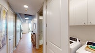 This 1-bedroom, 1-bathroom residence in Baton Rouge, Louisiana, blends industrial-chic architecture with contemporary finishes throughout. The open living area makes a strong first impression with soaring ceilings that showcase exposed concrete beams and visible ductwork, complemented by warm hardwood flooring. Large windows invite natural light, while a ceiling fan adds both function and style to the space.

The kitchen is well-appointed with light gray shaker-style cabinetry, stainless steel appliances including a gas range and refrigerator, a white tile backsplash, and clean white countertops. Pendant lighting overhead adds a modern touch, and an adjacent dining nook provides a convenient space for everyday meals.

The bedroom offers a calm, comfortable retreat with neutral tones, hardwood flooring, and exposed beam accents that carry the industrial aesthetic throughout. The full bathroom features large-format marble-look tile flooring, a glass-enclosed shower, a dual-sink vanity with backlit mirror, and direct access to a dedicated closet with built-in cabinetry for ample storage.

A private balcony, accessible from the unit, provides sweeping elevated views of downtown Baton Rouge and the surrounding cityscape, making it an ideal spot for taking in the urban landscape.