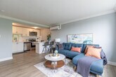 Located at 335 Melvin Ave in Hamilton, Ontario, this 1-bedroom, 1-bathroom unit offers a thoughtfully designed layout that maximizes every square foot. The combined kitchen and living area forms the heart of the home, featuring light wood-tone flooring, soft grey walls, and crown moulding that add a classic touch. The living area is bathed in natural light from a large picture window overlooking green treetops, with a wall-mounted mini-split unit providing climate control year-round. A classic white cast iron radiator complements the architectural character of the space.

The kitchen is outfitted with white shaker cabinetry, white subway tile backsplash, light countertops, and a full suite of stainless steel appliances including a dishwasher, electric range, and over-the-range microwave. Light hardwood flooring runs throughout the kitchen, adding warmth.

The bedroom is a comfortable, well-sized retreat with a large window framing outdoor greenery, a radiator beneath it, and light wood flooring. It connects directly to the hallway for easy access to the rest of the unit.

The bathroom features a clean, modern aesthetic with full white subway tile surrounding a soaking tub and shower combo, a wall-mounted vanity with chrome fixtures, and a mirrored medicine cabinet.