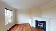This three-floor home is thoughtfully laid out across its levels, offering a functional and comfortable living environment. The main living area features warm hardwood-style flooring and a classic wood-burning fireplace framed by a white mantel, adding a welcoming focal point to the space. Crown molding and a textured ceiling lend a traditional character to the room.

The kitchen is well-appointed with honey-toned wood cabinetry, granite-look countertops, and black appliances including a range, refrigerator, and dishwasher. A window above the sink and a large sliding glass door in the adjoining dining area fill the space with natural light and provide views of the surrounding greenery, along with direct outdoor access. A chandelier overhead adds a refined touch to the dining space.

Upper-level bedrooms are carpeted and bright, with multiple windows framing natural views and creating an airy atmosphere. Bathrooms throughout include tub-shower combinations with clean white surrounds and wood vanities with ample storage.

The attached garage offers generous vehicle storage with a sectional overhead door. The lower-level unfinished basement houses the furnace, water heater, electrical panel, and utility sink, providing essential infrastructure and additional storage potential.