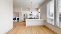 This contemporary 1-bedroom apartment in Metuchen, NJ, offers 640 square feet of efficient living space. The open floor plan maximizes the use of space, creating a seamless flow between the living areas. The kitchen is a highlight, boasting sleek white cabinetry, stainless steel appliances, and a practical island with a sink, perfect for both meal preparation and casual dining.

The bedroom, measuring 140 square feet, features large windows that flood the space with natural light and provide views of the surrounding area. A spacious closet offers ample storage. The bathroom continues the modern aesthetic with a vanity in a soft gray tone, complemented by a large mirror and stylish lighting.

Throughout the apartment, light-colored walls and warm wood-toned flooring create a bright, inviting atmosphere. The inclusion of in-unit laundry adds convenience to daily living. Large windows in every room not only brighten the space but also offer a connection to the outside world, enhancing the overall living experience in this well-designed urban dwelling.