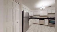 This two-floor residence in West Hartford, CT offers a practical and well-appointed layout throughout its two levels. The kitchen is a standout space, featuring white cabinetry, dark granite-style countertops, light tile flooring, and stainless steel appliances including a refrigerator, stove, and dishwasher. A chandelier adds a touch of elegance overhead. The living area is generously sized, with plush carpeting, a brick fireplace with built-in shelving, and a sliding glass door fitted with vertical blinds that opens to bring in natural light. A chandelier accentuates the room's welcoming ambiance. The bedrooms are carpeted and neutrally toned, with large windows that allow ample natural light to filter through. One room features an angled ceiling detail and a wide horizontal window, adding architectural character. The bathrooms are finished with white tile flooring and dark countertops, offering a clean, functional aesthetic, with one featuring a glass-door shower enclosure and accessibility grab bars. Throughout the space, neutral wall tones and consistent finishes create a cohesive feel. The two-floor configuration provides a clear separation of living areas, making this West Hartford residence both functional and comfortable.