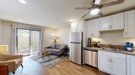 This thoughtfully designed one-bedroom, one-bathroom unit in Escondido, California, makes excellent use of its compact footprint, offering a comfortable and modern living experience. The open-concept kitchen and living area serves as the heart of the home, featuring white shaker cabinetry, granite-style countertops, and a full suite of stainless steel appliances, including a refrigerator, electric range, microwave, and dishwasher. A ceiling fan overhead adds to the functionality of the space. Wood-look plank flooring flows throughout, lending warmth and visual continuity to every room. The living area is bright and inviting, with recessed lighting and a sliding glass door that opens onto a private outdoor patio — ideal for enjoying Escondido's sunny Southern California climate. The bedroom is a serene retreat, accommodating a full-sized bed comfortably, and is enhanced by a ceiling fan, natural light from a window with blinds, and access to a dedicated closet. The bathroom is clean and well-appointed, featuring a tub/shower combination, a single vanity with stone-look countertop, white cabinetry, and continued wood-look flooring. Neutral tones and recessed lighting throughout create a cohesive, modern ambiance well-suited for comfortable everyday living.