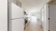 Located at 728 Meaford Ave in Langford, BC, this efficiently designed single-floor unit offers a clean, contemporary aesthetic ideal for comfortable everyday living. The open-concept layout maximizes the available footprint, creating a cohesive and functional living environment.

The kitchen is a standout feature, outfitted with crisp white cabinetry, sleek bar-pull hardware, and granite-look countertops. A classic white subway tile backsplash adds a timeless touch, while a full suite of stainless steel appliances — including an electric range, over-the-range microwave, dishwasher, and refrigerator — ensures the space is fully equipped for daily use. Light wood-look flooring runs seamlessly throughout, lending warmth and continuity to the interior.

The living area is bright and open, with clean white walls and the same durable flooring underfoot. A sliding glass door invites natural light deep into the space and provides direct access to an outdoor patio, offering a pleasant connection to the outdoors. A wall-mounted ductless air conditioning unit and baseboard heaters ensure year-round comfort. The overall design is minimal and modern, making excellent use of every square foot in this well-appointed Langford residence.