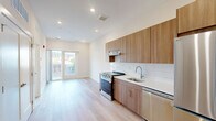 Located at 130 W Girard Ave in Philadelphia's vibrant 19123 zip code, this modern 1-bedroom, 1-bathroom unit offers a thoughtfully designed open-concept layout finished with light hardwood flooring and recessed lighting throughout. The kitchen is a standout feature, showcasing warm wood cabinetry extending to the ceiling, a white subway tile backsplash, clean white countertops, and a full suite of stainless steel appliances including a gas range and refrigerator. The kitchen flows seamlessly into the living area, which is bathed in natural light from glass double doors that open onto a private balcony with views of the surrounding Philadelphia streetscape. The bedroom is a bright, clean space with a large window overlooking the neighborhood, complemented by light hardwood floors and a recessed ceiling light. The bathroom features light tile flooring and a clean, minimalist design. Additional conveniences include two closets and a dedicated laundry area within the unit. The overall aesthetic is modern and neutral, emphasizing clean lines, natural light, and functional design — ideal for those seeking a well-appointed urban home in a dynamic Philadelphia neighborhood.
