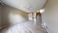 Located at 300 E Shelbourne Dr in Normal, IL, this two-story home offers three bedrooms and one bathroom across two thoughtfully laid-out floors. Light-toned hardwood flooring runs throughout the entire home, creating a cohesive and clean aesthetic from room to room.

The main floor features an open living area with warm taupe-painted walls, a ceiling fan, and a built-in louvered closet for additional storage. A staircase with a sleek railing connects the two levels. The kitchen is well-equipped with stainless steel appliances — including a gas range, over-the-range microwave, and refrigerator — complemented by gray shaker-style cabinetry, light countertops, and a single-basin sink. A window and exterior door provide natural light and direct access to the outside.

Upstairs, three bedrooms continue the home's consistent hardwood flooring and neutral wall tones. The primary bedroom is a comfortable size, while the additional bedrooms each feature windows that invite natural light. A ceiling fan is present in at least one of the upper bedrooms. The single full bathroom is finished with a pedestal sink, a mirrored medicine cabinet, and a shower-tub combination. A hallway connects the upper-floor rooms efficiently. The home's practical layout and consistent finishes make it a functional and attractive residence.