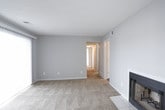 This single-floor home offers a well-organized layout with a variety of comfortable living spaces throughout. The living room serves as a central gathering area, highlighted by a classic fireplace set against neutral gray walls and plush wall-to-wall carpeting, creating a warm and inviting atmosphere. A sliding glass door in one of the living areas opens to an outdoor deck, allowing natural light to fill the room and providing a seamless connection to the exterior.

The kitchen is equipped with white cabinetry, light countertops, and a full suite of black appliances, including a refrigerator, electric range with overhead ventilation, and dishwasher. Wood-look flooring in the kitchen adds warmth and durability to the space.

The bedrooms feature soft carpeting, ceiling fans with integrated lighting, and windows that invite natural light and outdoor views. The primary bedroom includes dual windows and direct access to what appears to be a closet and an en-suite bathroom. An additional bedroom also benefits from a ceiling fan and natural light.

The bathrooms are finished with wood-look vinyl flooring and clean white fixtures. One bathroom includes a walk-in shower stall, while the other offers a full shower-tub combination, both accented by textured walls for added character throughout.