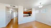 This single-story residence offers a functional and well-organized layout with a clean, neutral aesthetic throughout. The open-concept living and kitchen area serves as the heart of the home, where a pass-through peninsula connects the two spaces. The kitchen is well-equipped with warm-toned wood cabinetry, light countertops, and a full suite of black appliances, including a gas range, over-the-range microwave, refrigerator, and dishwasher. Light wood-style flooring runs through the main living and kitchen areas, contributing to a bright and cohesive feel.

The bedrooms feature a mix of light wood flooring and plush carpet, and each is fitted with a ceiling fan with light kit. The rooms are bright, with windows dressed in horizontal blinds allowing natural light to filter in. White walls throughout provide a clean, neutral canvas.

The bathroom includes a wood-tone vanity with a single sink, light countertop, large mirror, and a tiled tub-shower combination with brushed nickel fixtures and hardware.

A dedicated laundry alcove houses a full-size side-by-side washer and dryer with overhead shelving, adding practical in-unit convenience to this well-appointed home.