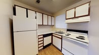 Located at 10714 Abercorn Ext in Savannah, GA, this single-floor unit offers a practical and comfortable layout throughout. The kitchen is efficiently designed in an L-shaped configuration, featuring white cabinetry with wood-tone trim, a full-size refrigerator, an electric range, a dishwasher, and an under-cabinet range hood. A window above the sink allows for natural light, and durable laminate wood flooring ties the space together. The living area is open and airy, finished with neutral beige carpeting and warm-toned walls. A large window invites natural light, and a direct sightline to the kitchen enhances the connected feel of the space. The bedrooms are carpeted and feature textured ceilings, sliding-pane windows with blinds, and clean, neutral walls that offer a calm and versatile environment. The bathroom includes a full tub-shower combination with a window above for ventilation and light, a single vanity with a mirror cabinet, and wood-tone flooring. A highlight of this unit is the generously sized walk-in closet, outfitted with dual hanging rods and built-in shelving, providing ample storage. Overall, the unit presents a clean, functional living environment well-suited for everyday comfort.