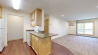 This 650 square foot one-bedroom apartment in Burnsville, Minnesota, offers a blend of comfort and functionality. The kitchen is a standout feature, boasting light wood cabinetry, granite countertops, and a suite of white appliances. The galley-style layout maximizes space efficiency, with ample storage and a dishwasher for convenience.

The living area is carpeted and spacious, featuring a large window that floods the room with natural light and provides outdoor views. A ceiling fan adds both style and practicality. The bedroom, also carpeted, offers a cozy retreat with a generous closet space.

The bathroom is modern and clean, with a combined tub and shower unit, a single vanity with granite countertop, and additional storage. Throughout the apartment, neutral tones create a versatile backdrop for personal decor.

Hardwood-style flooring in the kitchen and entryway adds a touch of elegance and ease of maintenance. The open floor plan between the kitchen and living area enhances the sense of space, making this compact apartment feel larger than its actual square footage.