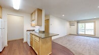 This 650 square foot one-bedroom apartment in Burnsville, Minnesota, offers a blend of comfort and functionality. The kitchen is a standout feature, boasting light wood cabinetry, granite countertops, and a suite of white appliances. The galley-style layout maximizes space efficiency, with ample storage and a dishwasher for convenience.

The living area is carpeted and spacious, featuring a large window that floods the room with natural light and provides outdoor views. A ceiling fan adds both style and practicality. The bedroom, also carpeted, offers a cozy retreat with a generous closet space.

The bathroom is modern and clean, with a combined tub and shower unit, a single vanity with granite countertop, and additional storage. Throughout the apartment, neutral tones create a versatile backdrop for personal decor.

Hardwood-style flooring in the kitchen and entryway adds a touch of elegance and ease of maintenance. The open floor plan between the kitchen and living area enhances the sense of space, making this compact apartment feel larger than its actual square footage.