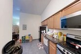 This 400 square foot apartment, located at 205 Dryden Rd in Ithaca, NY, offers a well-designed living space perfect for single occupancy or a couple. The unit features an open-concept layout, maximizing the use of limited space. The kitchen is equipped with modern stainless steel appliances, including a refrigerator, stove, and built-in microwave. Ample wood cabinetry and granite countertops provide storage and food preparation areas. 

The living area doubles as a bedroom, with space for a bed and seating. Wood-look flooring throughout creates a warm atmosphere, while large windows allow natural light to brighten the space. A full bathroom includes a shower/tub combination and a vanity with storage.

The apartment showcases thoughtful design elements like a full-length mirror near the entry and creative storage solutions. Personal touches such as colorful artwork, a dining table, and decorative items give the space a homey feel. Despite its compact size, this apartment offers all the essentials for comfortable urban living in a prime Ithaca location.