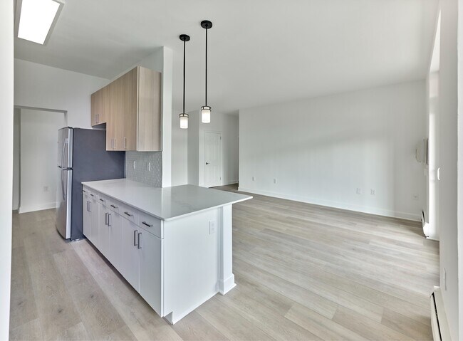 Cocina luminosa y moderna con encimeras de cuarzo y electrodomésticos de acero inoxidable en Crestwood Apartments en Wayne, PA - Crestwood