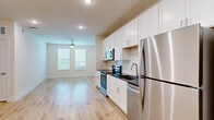 Located at 4710 Old Decatur Rd in Fort Worth, TX, this thoughtfully designed 2-bedroom, 2-bathroom single-floor unit offers a clean, contemporary living experience. The open-concept layout seamlessly connects the kitchen, dining, and living areas, creating a bright and functional shared space. The kitchen is well-appointed with white shaker cabinets, dark granite countertops, a classic subway tile backsplash, and a full suite of stainless steel appliances including a range, microwave, dishwasher, and refrigerator. Light wood-look flooring runs throughout the unit, contributing to a cohesive and modern aesthetic. The living area benefits from recessed lighting and natural light from multiple windows fitted with blinds. Both bedrooms are comfortably sized, featuring ceiling fans, dual windows for ample natural light, and dedicated closets with built-in shelving and hanging rods. The primary bedroom includes a generously sized walk-in closet. The bathrooms feature subway tile surrounds with soaking tubs and brushed nickel fixtures. Additional conveniences include a dedicated laundry area, a utility room, and a hallway connecting the private quarters. The unit presents a clean, move-in-ready interior with a neutral color palette throughout.