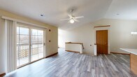 Located at 630 N Spring St in Port Washington, Wisconsin, this well-laid-out 2-bedroom, 2-bathroom residence offers a comfortable and functional floor plan with consistent light-toned luxury vinyl plank flooring throughout. The open living area is highlighted by vaulted ceilings, a ceiling fan with light fixture, and a sliding glass door that opens to a private deck, filling the space with natural light and providing outdoor access. Warm beige walls and classic wood baseboards contribute to a clean, neutral aesthetic throughout. The kitchen is thoughtfully designed with warm oak cabinetry, a peninsula with a white countertop ideal for casual dining, stainless steel appliances including a refrigerator and range, an under-cabinet range hood, and a walk-in pantry closet for additional storage. The primary bedroom is generously sized with a large picture window offering exterior views, a ceiling fan, and a textured ceiling. The second bedroom is well-proportioned with its own closet and ample natural light. The two bathrooms are clean and functional, featuring wood-toned vanities, marble-style countertops, mirrored medicine cabinets, and tub/shower combinations with tile surrounds. A staircase connects to the lower level, rounding out this practical and inviting home.